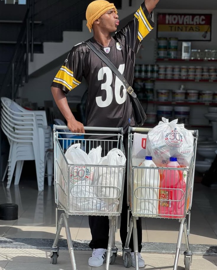 Jovem com camisola desportiva junto a carrinhos de compras