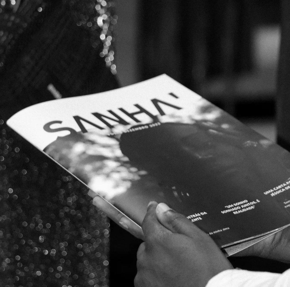 Mão a segurar uma revista SΛNHΛ', a preto e branco